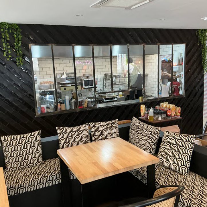 Banquette à motifs et cuisine ouverte du Café Jules